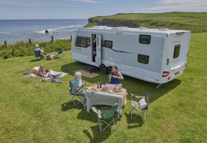 Family relaxing outside a motorhome